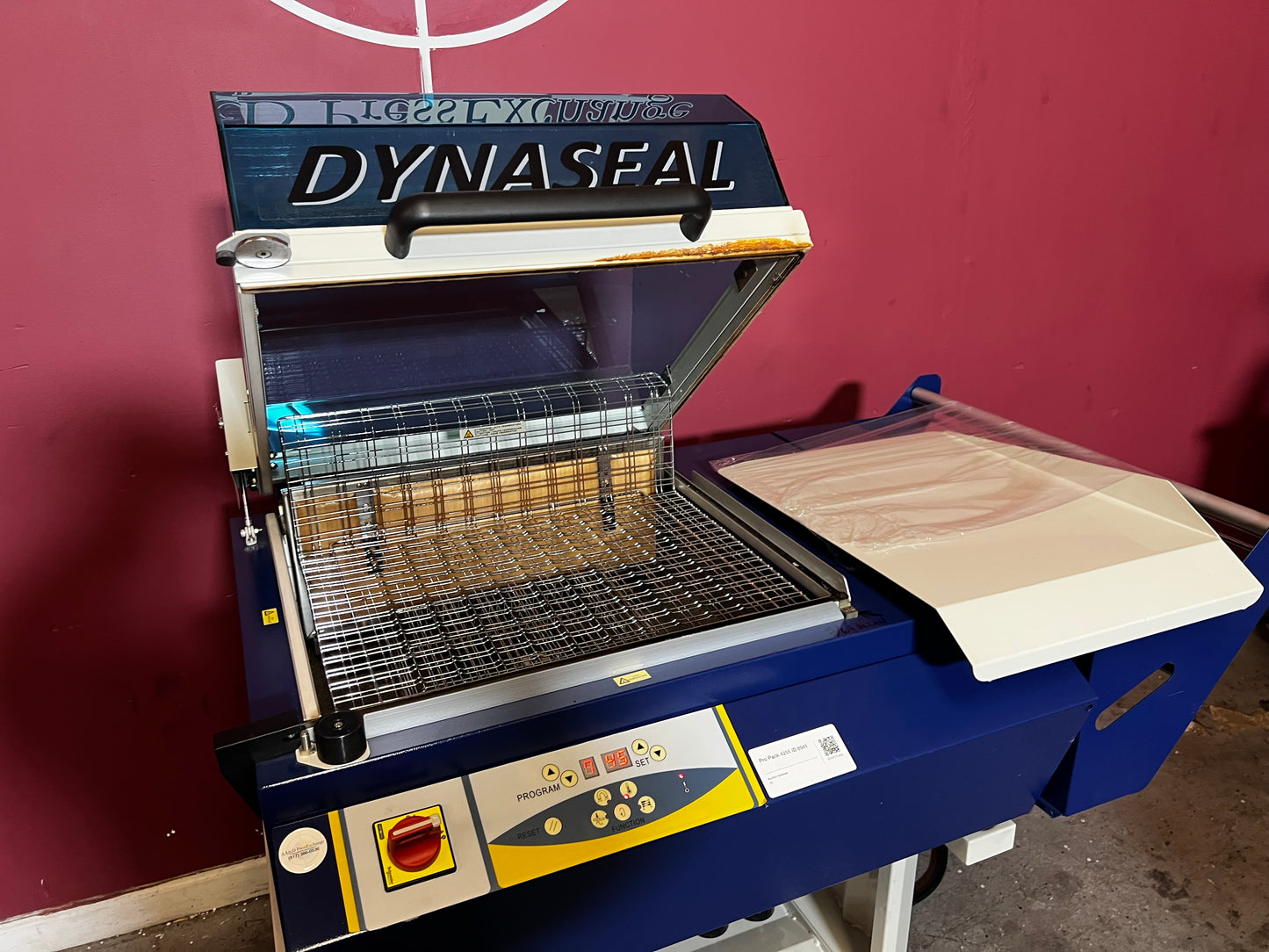 Used Dynaseal Shrink Wrapper angled side view showing conveyor and sealing area – AA&D PressExchange