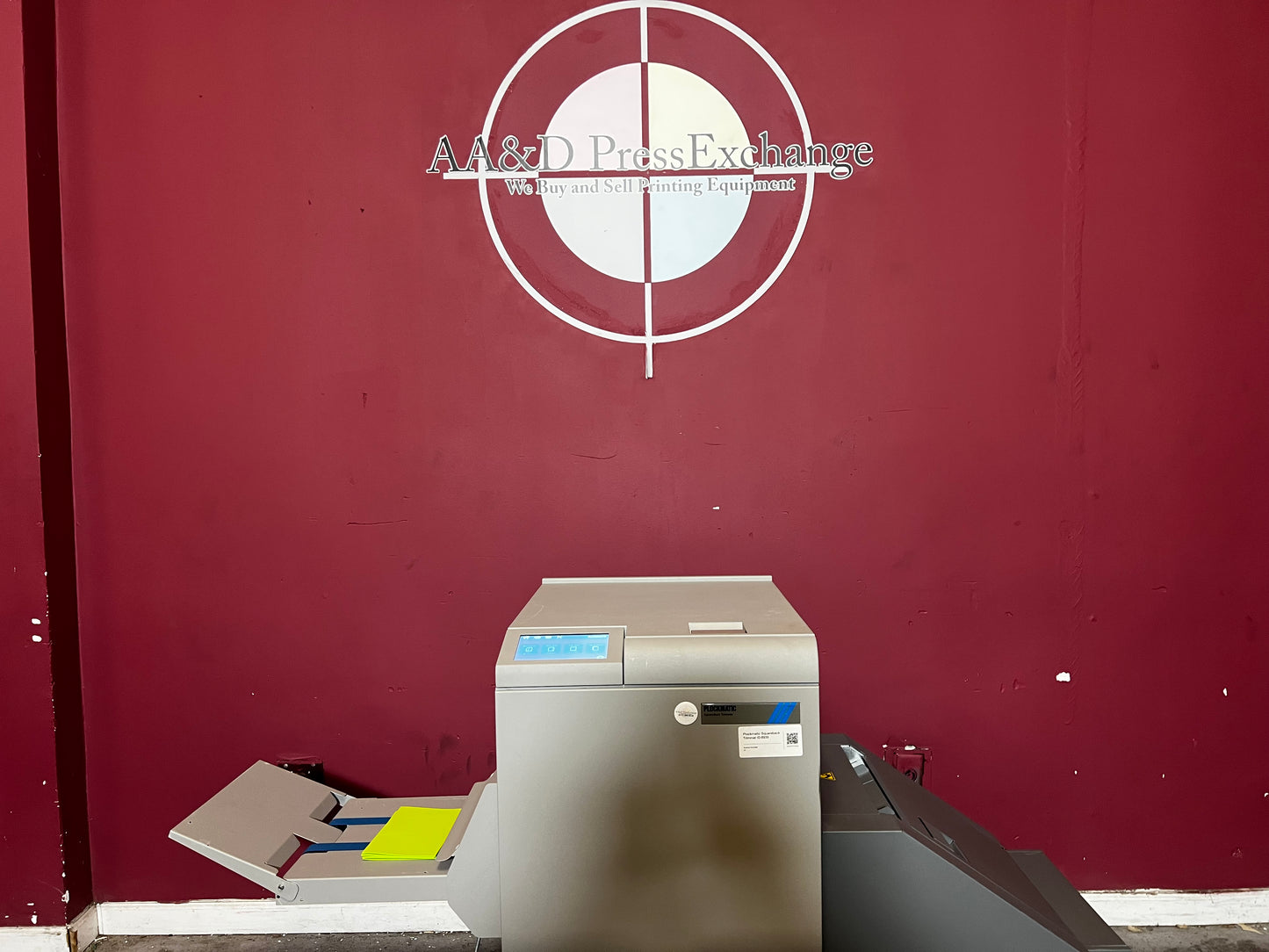 Used Plockmatic SquareBack Trimmer side view with inline connection to booklet maker – AA&D PressExchange