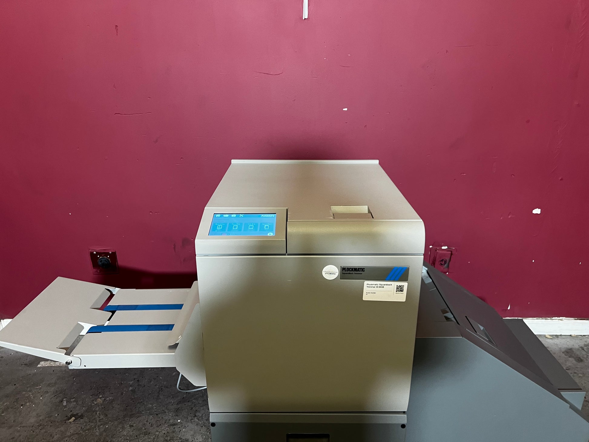 Used Plockmatic SquareBack Trimmer close-up of booklet exit area with trimmed edges – AA&D PressExchange