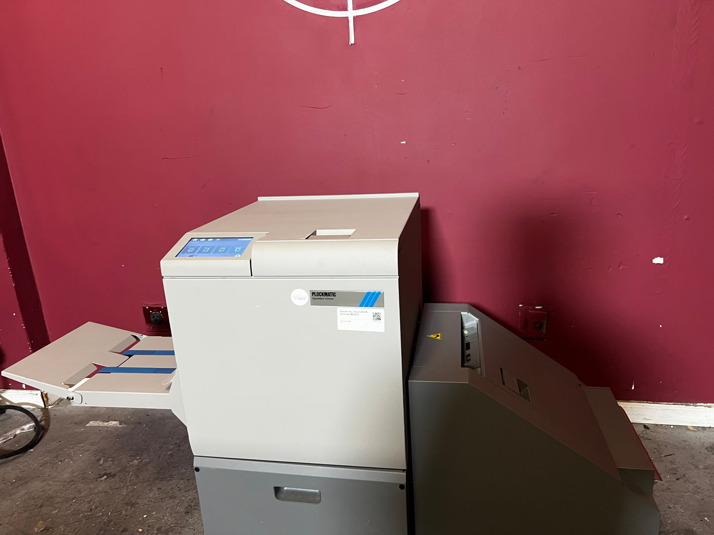 Used Plockmatic SquareBack Trimmer rear view highlighting booklet output tray – AA&D PressExchange