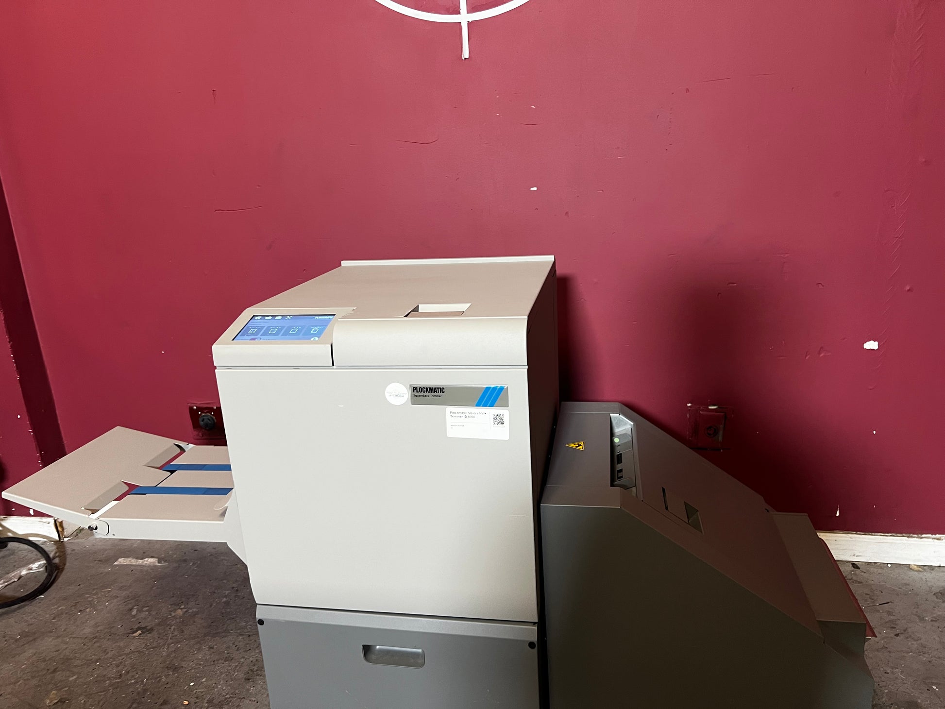 Used Plockmatic SquareBack Trimmer rear view highlighting booklet output tray – AA&D PressExchange