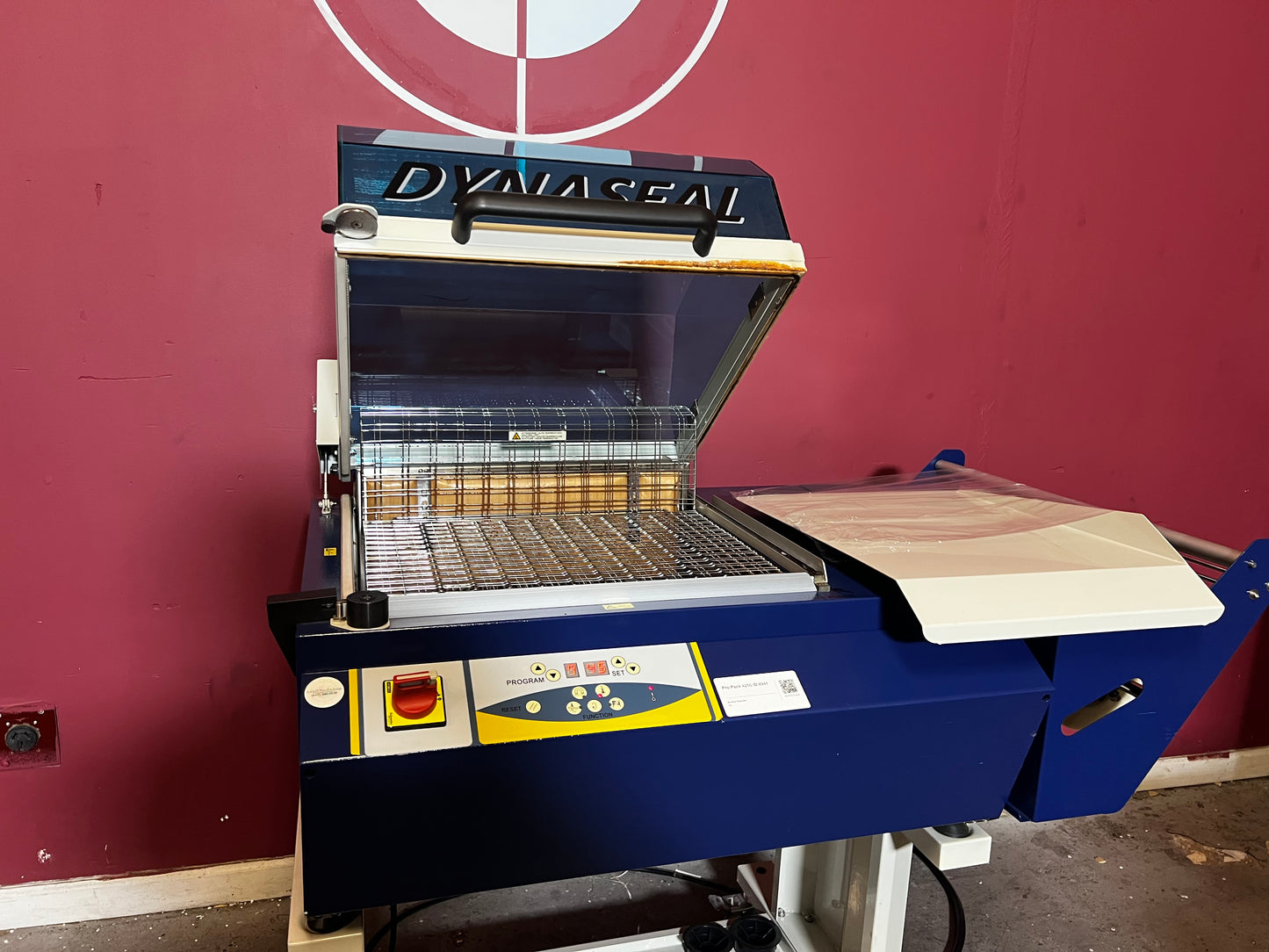 Used Dynaseal Shrink Wrapper side view showing full packaging line setup – AA&D PressExchange