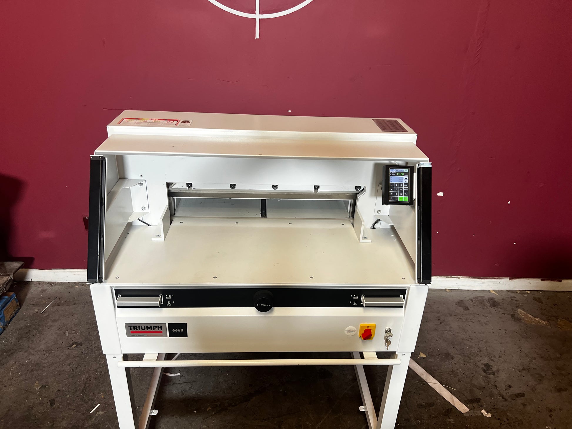 Used Triumph 6660 paper cutter front/side view highlighting automatic cutting features – AA&D PressExchange