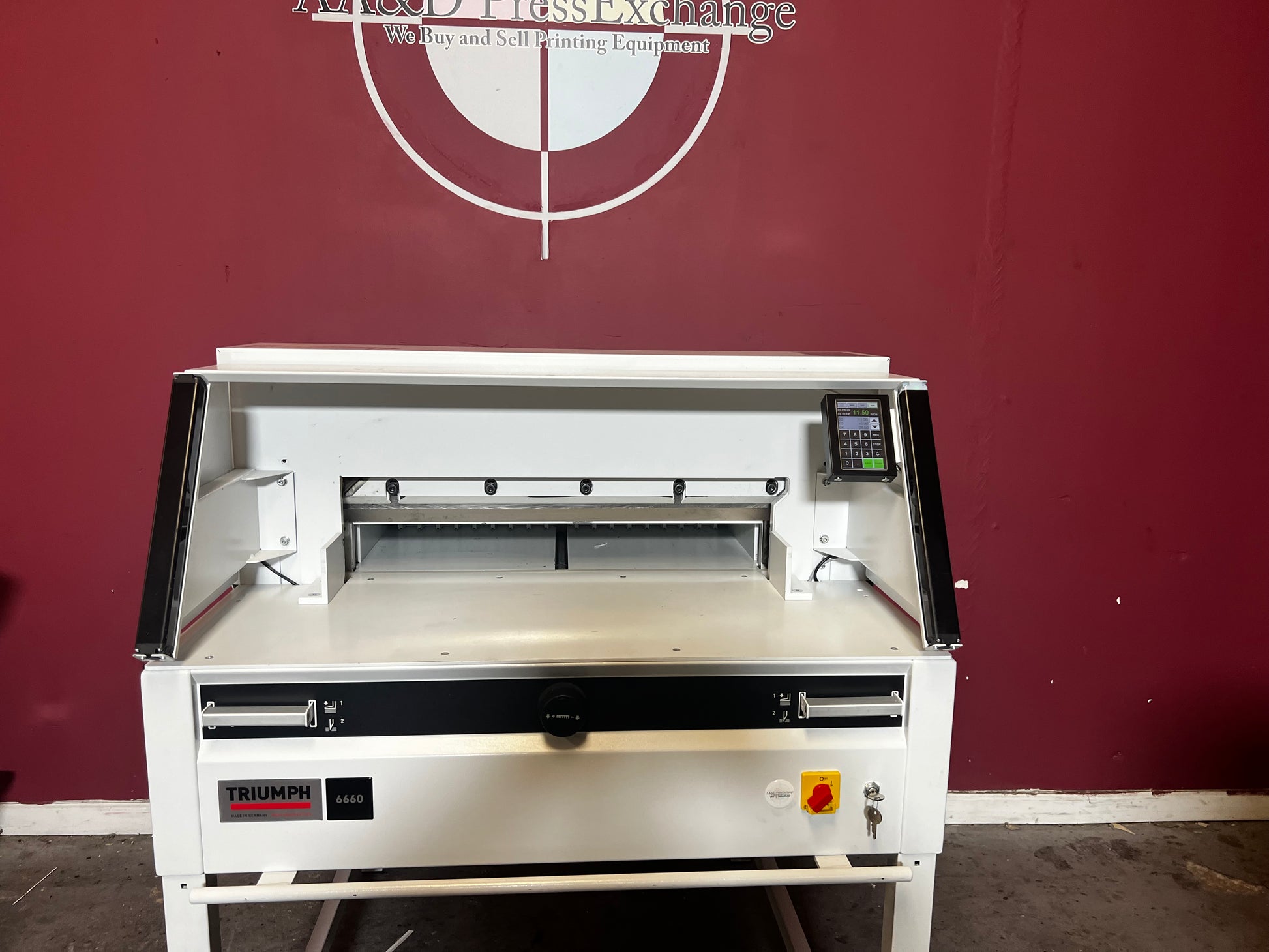 Used Triumph 6660 programmable paper cutter angled view in production setup – AA&D PressExchange