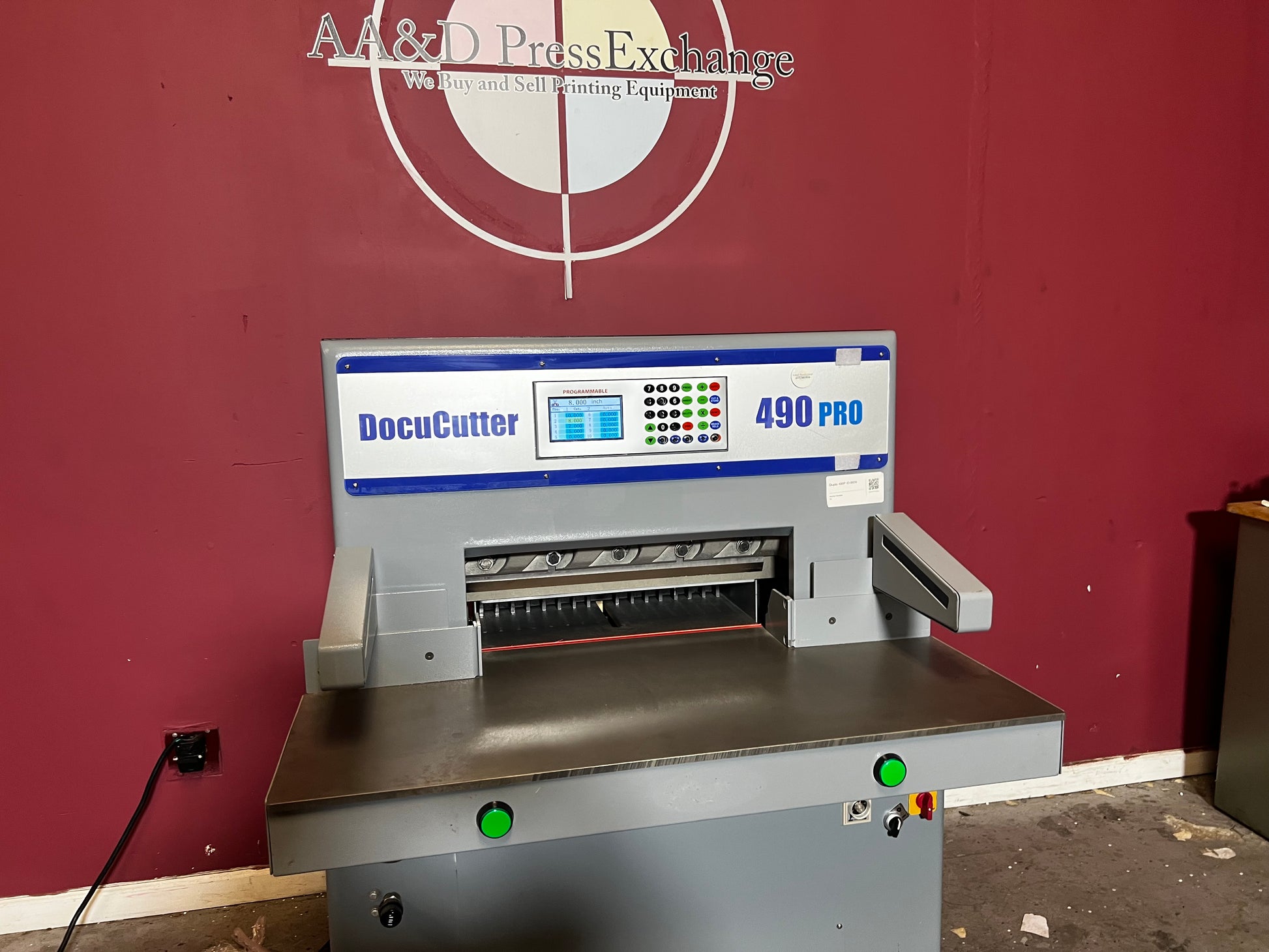 AA&D PressExchange Used Duplo 490 PRO hydraulic paper cutter angled side view showing cutting table
