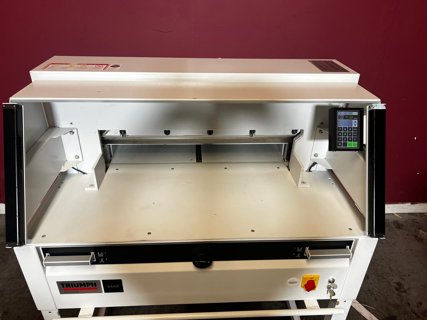 Used Triumph 6660 paper cutter front angle showing cutting deck and safety shield – AA&D PressExchange