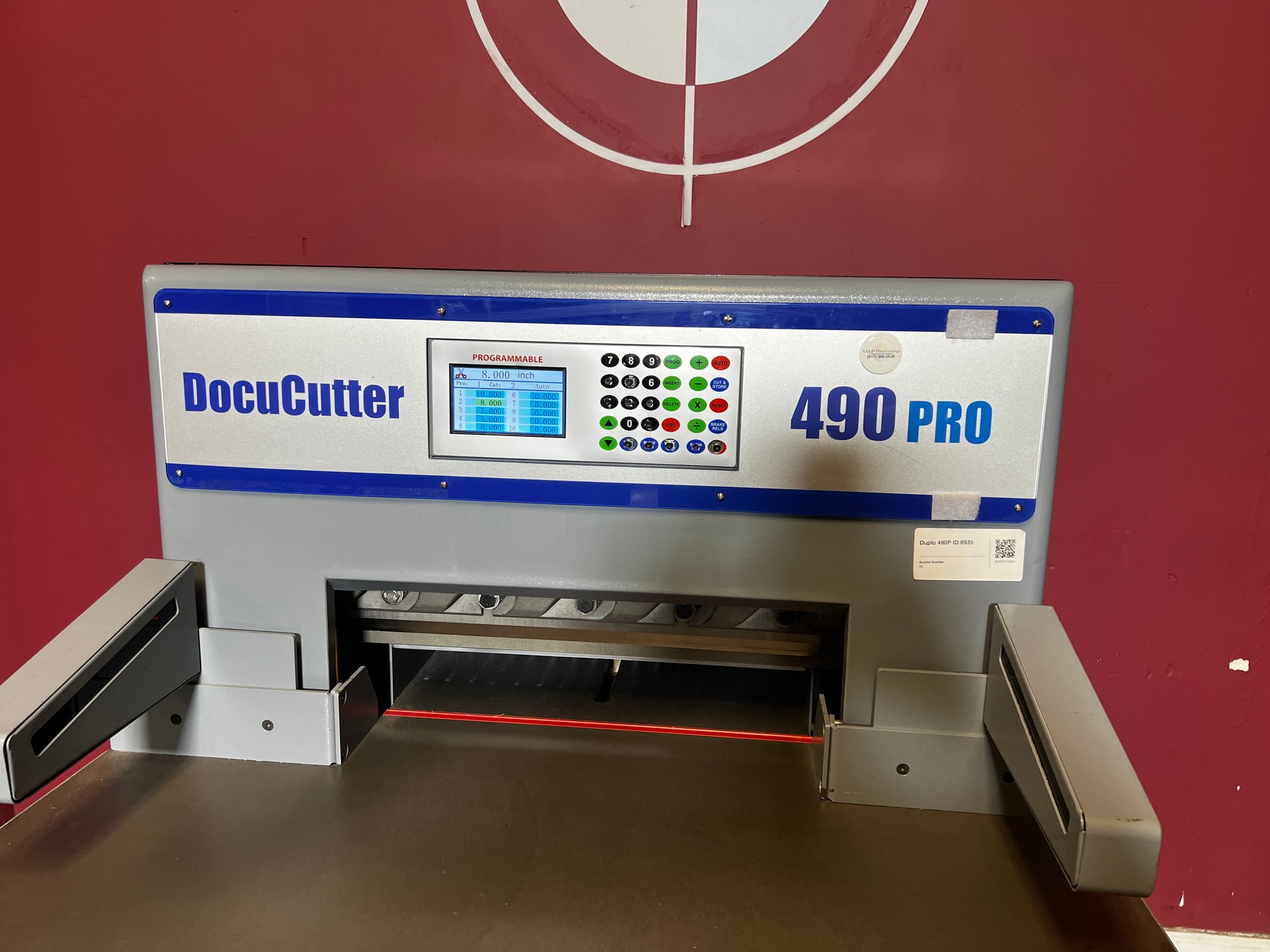 AA&D PressExchange Used Duplo 490 PRO hydraulic paper cutter angled view showing touchscreen and cutting area