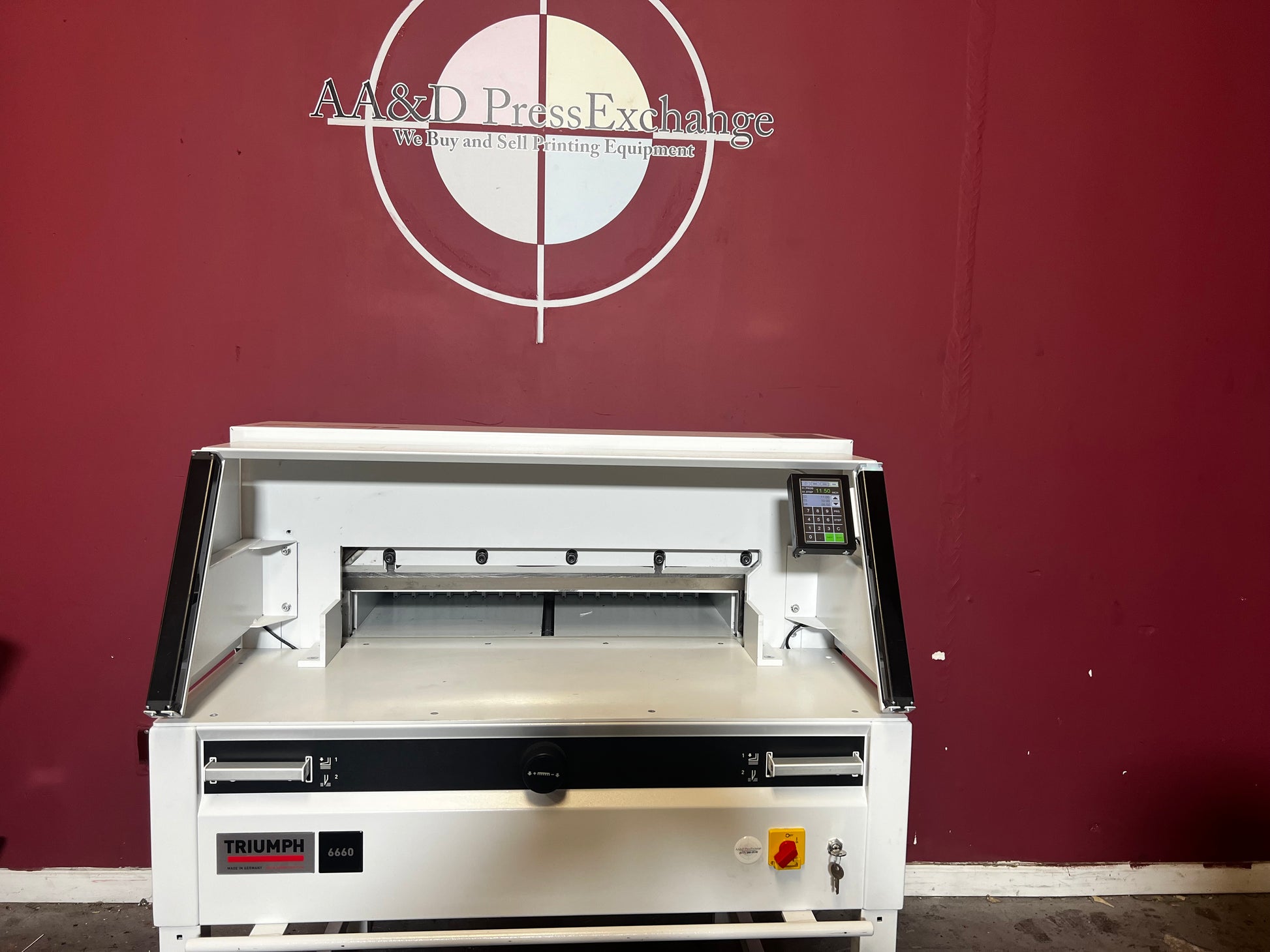 Used Triumph 6660 paper cutter front view showing safety guard and cutting table – AA&D PressExchange